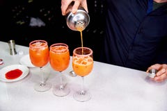 Dans les verres avec de la glace le barman verse des cocktails images libres de droits Dans les verres avec de la glace le barman verse des cocktails images libres de droits