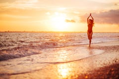 Danse insousiante de femme dans le coucher du soleil sur la plage photo libre de droits Danse insousiante de femme dans le coucher du soleil sur la plage photo libre de droits