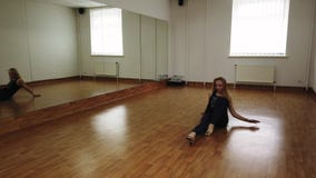 Danza femenina del entrenamiento del bailar?n mientras que ensaya en estudio de la danza Danza femenina del entrenamiento del bailar?n mientras que ensaya en estudio de la danza