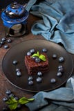 Dark chocolate and cocoa brownie cakes dessert with mint against stone background