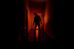 Dark Corridor With Cabinet Doors And Lights With Silhouette Of Spooky Horror Man Standing With Different Poses. Stock Photography