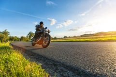 Dark motorbiker riding high power motorbike in sunset Stock Photography Dark motorbiker riding high power motorbike in sunset Stock Photography