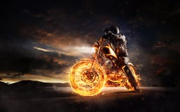 Dark motorbiker staying on burning motorcycle in sunset light Royalty Free Stock Photos Dark motorbiker staying on burning motorcycle in sunset light Royalty Free Stock Photos