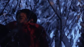 Dark silhouette of young male wandering in snowy winter forest at silent night. stock video Dark silhouette of young male wandering in snowy winter forest at silent night. stock video