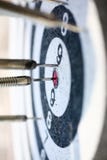 The dart game sticks out in the center of the red stock image The dart game sticks out in the center of the red stock image