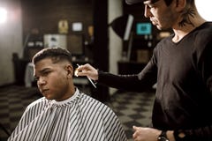 Das Friseurscherenhaar auf den Seiten für einen stilvollen schwarz-haarigen Mann im Friseursalon Männer ` s Mode und Art stockbilder Das Friseurscherenhaar auf den Seiten für einen stilvollen schwarz-haarigen Mann im Friseursalon Männer ` s Mode und Art stockbilder