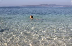 Das kleine Mädchen schwimmt im haarscharfen Meer kroatien lizenzfreie stockfotografie Das kleine Mädchen schwimmt im haarscharfen Meer kroatien lizenzfreie stockfotografie