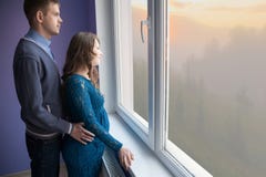 Das Paar schaut heraus das Fenster stockfotografie Das Paar schaut heraus das Fenster stockfotografie