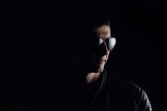 Das Portr?t des Jungemannes Nahaufnahme des ernsten jungen Mannes in einer schwarzen Lederjacke und in der Sonnenbrille stockbild Das Portr?t des Jungemannes Nahaufnahme des ernsten jungen Mannes in einer schwarzen Lederjacke und in der Sonnenbrille stockbild