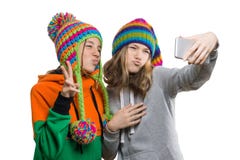 Das Winterporträt von zwei glücklichen schönen Jugendfreundinnen in den Strickmützen, die Spaß mit Handy, selfie nehmend haben, l stockfotos Das Winterporträt von zwei glücklichen schönen Jugendfreundinnen in den Strickmützen, die Spaß mit Handy, selfie nehmend haben, l stockfotos
