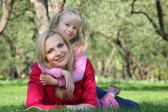 Daughter embraces mother lying on grass Stock Photos Daughter embraces mother lying on grass Stock Photos