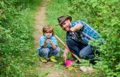 Day of earth. Boy and father in nature. Gardening tools. Planting flowers. Dad teaching little son care plants. Little royalty free stock image Day of earth. Boy and father in nature. Gardening tools. Planting flowers. Dad teaching little son care plants. Little royalty free stock image