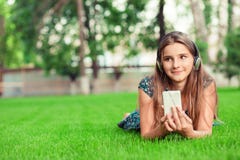 daydreaming Счастливая молодая милая женщина студента со шлемофоном смартф стоковая фотография rf daydreaming Счастливая молодая милая женщина студента со шлемофоном смартф стоковая фотография rf