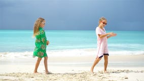 De aanbiddelijke meisjes hebben heel wat pret op het strand Twee mooie jonge geitjes die op de kust dansen stock video De aanbiddelijke meisjes hebben heel wat pret op het strand Twee mooie jonge geitjes die op de kust dansen stock video