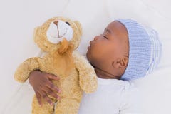 De aanbiddelijke slaap van de babyjongen vreedzaam met teddy royalty-vrije stock fotografie De aanbiddelijke slaap van de babyjongen vreedzaam met teddy royalty-vrije stock fotografie