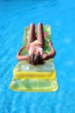 De aantrekkelijke, slanke jonge dame die op opblaasbaar liggen sunbed op swimmi stock fotografie De aantrekkelijke, slanke jonge dame die op opblaasbaar liggen sunbed op swimmi stock fotografie