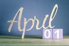 1º de abril dia 1 do mês, calendário diário na tabela de madeira com fundo roxo ou violeta Tema do tempo de mola Fotos de Stock