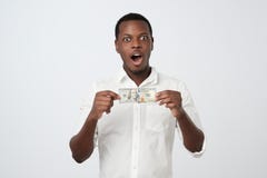 De Afrikaanse mens in wit overhemd houdt honderd dollars in zijn handen bekijkend de camera stock fotografie De Afrikaanse mens in wit overhemd houdt honderd dollars in zijn handen bekijkend de camera stock fotografie