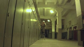 De arbeider gaat naar elektroruimte en schrijft gegevens stock videobeelden De arbeider gaat naar elektroruimte en schrijft gegevens stock videobeelden