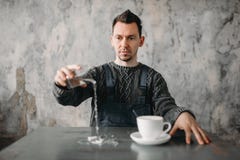 De autistische mens giet water van het glas op lijst royalty-vrije stock fotografie De autistische mens giet water van het glas op lijst royalty-vrije stock fotografie