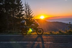 De avonturenmotorfiets, silhouetteert toeristische motor de bergpieken in de donkere kleuren van de zonsondergang De ruimte van h royalty-vrije stock foto De avonturenmotorfiets, silhouetteert toeristische motor de bergpieken in de donkere kleuren van de zonsondergang De ruimte van h royalty-vrije stock foto