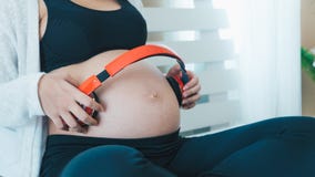 De Aziatische zwangere vrouwen openen het lied voor de baby in de buik stock foto De Aziatische zwangere vrouwen openen het lied voor de baby in de buik stock foto
