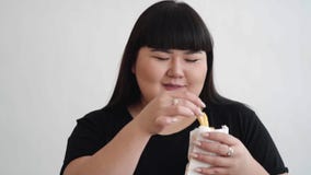 De Aziatische zwarte overhemdsvrouwen genieten van etend met haar frieten in handen Gelukkig concept stock videobeelden De Aziatische zwarte overhemdsvrouwen genieten van etend met haar frieten in handen Gelukkig concept stock videobeelden