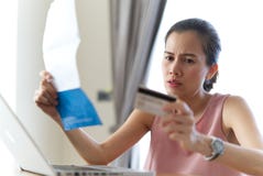 De beklemtoonde Aziatische creditcard en de rekeningen die van de vrouwenholding zorg over haar schuld voelen royalty-vrije stock fotografie De beklemtoonde Aziatische creditcard en de rekeningen die van de vrouwenholding zorg over haar schuld voelen royalty-vrije stock fotografie