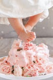 De benenvoeten die van het babymeisje in cake tijdens haar verjaardagsviering stappen Stock Fotografie De benenvoeten die van het babymeisje in cake tijdens haar verjaardagsviering stappen Stock Fotografie