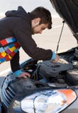 De bestuurder die van de auto de motor van de auto onderzoekt stock afbeelding De bestuurder die van de auto de motor van de auto onderzoekt stock afbeelding