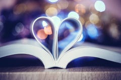 De Boekpagina verfraait aan hartvorm met viering bokeh lig Stock Foto De Boekpagina verfraait aan hartvorm met viering bokeh lig Stock Foto