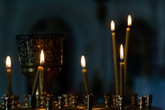 De brandwond van kerkkaarsen in een kandelaar tegen de achtergrond van ico stock fotografie De brandwond van kerkkaarsen in een kandelaar tegen de achtergrond van ico stock fotografie