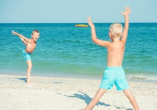 De broers spelen met frisbee op het strand De vakantie van de zomer royalty-vrije stock fotografie De broers spelen met frisbee op het strand De vakantie van de zomer royalty-vrije stock fotografie