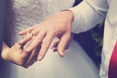 De bruidegom zet de ring op de vinger van de bruid, overhandigt close-up Het stemmen in de stijl van instagram stock afbeeldingen De bruidegom zet de ring op de vinger van de bruid, overhandigt close-up Het stemmen in de stijl van instagram stock afbeeldingen