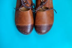De bruine schoenen van het vrouwen` s leer op blauwe achtergrond stock foto De bruine schoenen van het vrouwen` s leer op blauwe achtergrond stock foto