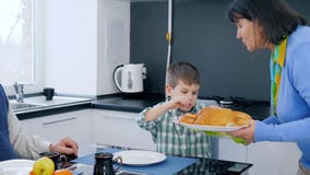 De brunch van de gepensioneerdefamilie, oma bracht heerlijk brood op schotel voor jong geitje en grootvaderzitting bij lijst stock videobeelden De brunch van de gepensioneerdefamilie, oma bracht heerlijk brood op schotel voor jong geitje en grootvaderzitting bij lijst stock videobeelden