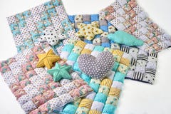De bundel van kleurrijk patchworked dekbedden met eenhoorn en speelt ontwerp en hoofdkussens op witte achtergrond mee royalty-vrije stock fotografie De bundel van kleurrijk patchworked dekbedden met eenhoorn en speelt ontwerp en hoofdkussens op witte achtergrond mee royalty-vrije stock fotografie