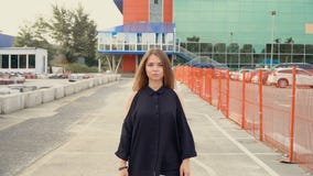 De camera volgt een jong aantrekkelijk brunette in het parkeerterrein stock video De camera volgt een jong aantrekkelijk brunette in het parkeerterrein stock video