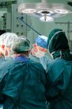 De chirurg van het team aan het werk in werkende ruimte royalty-vrije stock afbeeldingen De chirurg van het team aan het werk in werkende ruimte royalty-vrije stock afbeeldingen