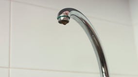 De close-uplengte van een kraan opent en waterbegin aan stroom in een gootsteen stock footage De close-uplengte van een kraan opent en waterbegin aan stroom in een gootsteen stock footage