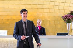De controle van de hotelreceptionnist bij de mens die zeer belangrijke kaart geven royalty-vrije stock foto's De controle van de hotelreceptionnist bij de mens die zeer belangrijke kaart geven royalty-vrije stock foto's