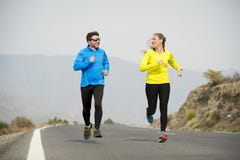 De de aantrekkelijke man en vrouw die van het sportpaar samen op de berglandschap van de asfaltweg lopen royalty-vrije stock afbeeldingen De de aantrekkelijke man en vrouw die van het sportpaar samen op de berglandschap van de asfaltweg lopen royalty-vrije stock afbeeldingen