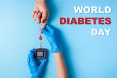 De diabetesdag van de inschrijvingswereld, Verpleegster die een hand van de bloedonderzoekmens ` s met rood bloed dalen en Glucos stock fotografie De diabetesdag van de inschrijvingswereld, Verpleegster die een hand van de bloedonderzoekmens ` s met rood bloed dalen en Glucos stock fotografie