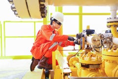 De elektro en Instrumententechnicus vervangt solenoïdeklep van sluitingsklep bij olie en gasbron ver platform royalty-vrije stock afbeeldingen De elektro en Instrumententechnicus vervangt solenoïdeklep van sluitingsklep bij olie en gasbron ver platform royalty-vrije stock afbeeldingen