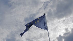 De EU-vlag die in de wind tegen een blauwe hemel golven Het concept patriottisme Langzame Motie stock videobeelden De EU-vlag die in de wind tegen een blauwe hemel golven Het concept patriottisme Langzame Motie stock videobeelden