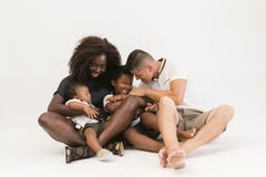 De familiezitting van het mixerras op vloer met 2 kinderen Gelukkig Paar royalty-vrije stock foto De familiezitting van het mixerras op vloer met 2 kinderen Gelukkig Paar royalty-vrije stock foto