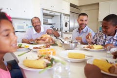 De Familiezitting van meerdere generaties rond Lijst die Maaltijd eten royalty-vrije stock afbeeldingen De Familiezitting van meerdere generaties rond Lijst die Maaltijd eten royalty-vrije stock afbeeldingen