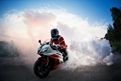 De fietser die op fietsweg blijven met rook van de band, uit:branden in moto toont De zonsondergang royalty-vrije stock foto De fietser die op fietsweg blijven met rook van de band, uit:branden in moto toont De zonsondergang royalty-vrije stock foto