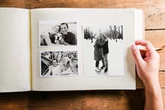 De fotoalbum van de handholding met beelden van hoger paar studio Stock Foto's De fotoalbum van de handholding met beelden van hoger paar studio Stock Foto's