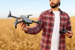 De gebaarde hipstermens toont kleine compacte hommel en houdt ver controlemechanisme in zijn hand De landbouwersagronoom bekijkt royalty-vrije stock fotografie De gebaarde hipstermens toont kleine compacte hommel en houdt ver controlemechanisme in zijn hand De landbouwersagronoom bekijkt royalty-vrije stock fotografie